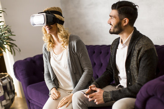 Young woman has a virtual reality glasses while man sitting