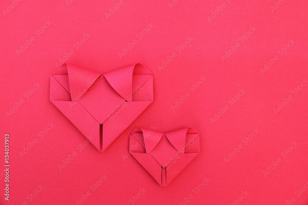 Poster two folding red paper hearts on red for pattern and background