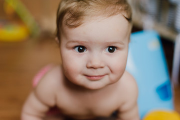 Smiling baby boy playing with toys in his room