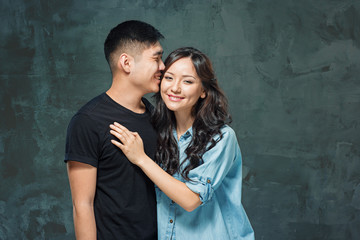 Portrait of smiling Korean couple on a gray