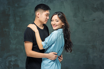 Portrait of smiling Korean couple on a gray