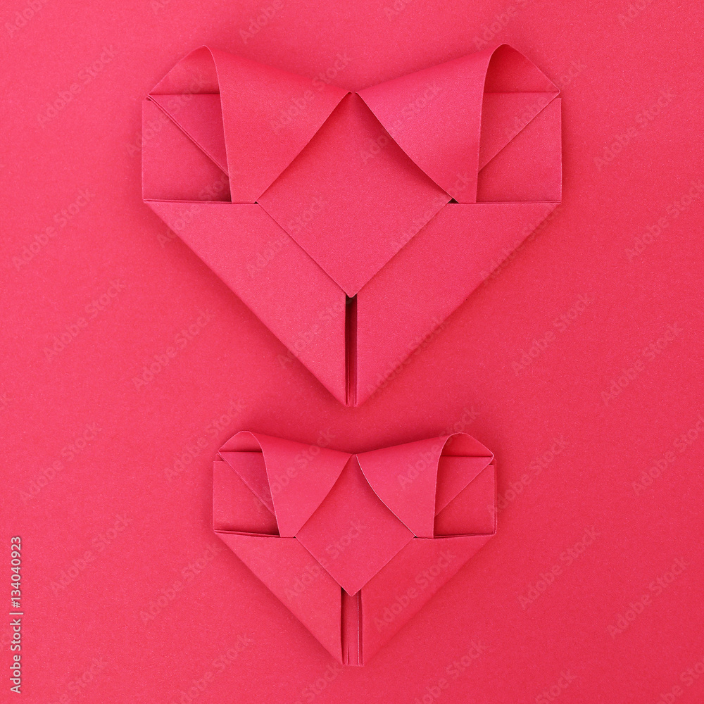 Poster two folding red paper hearts on red for pattern and background