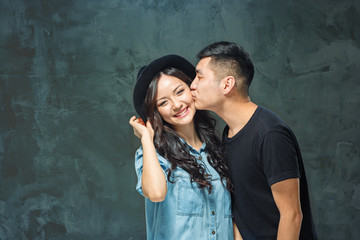 Portrait of smiling Korean couple on a gray