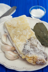 frozen cod fish with garlic on white plate