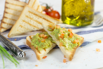 Toast with mashed avocado, olive oil and tomato