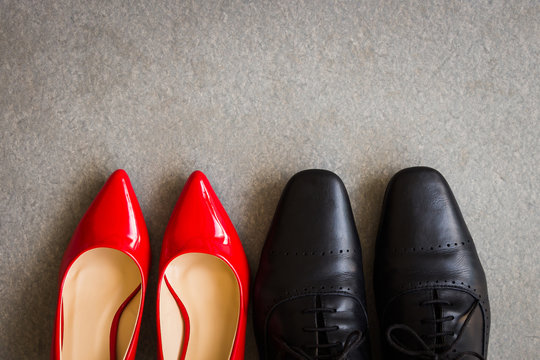 Black men shoes and red women shoes on gray background