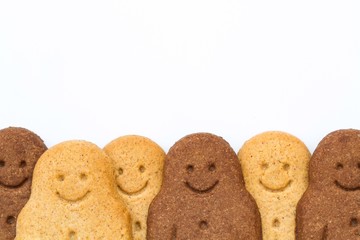 A row of black and white, happy and smiling gingerbread men representing racial harmony, diversity and equality on an isolated white background.