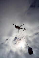 Fototapeta na wymiar Helicopter working on transporting material. Dangerous work.