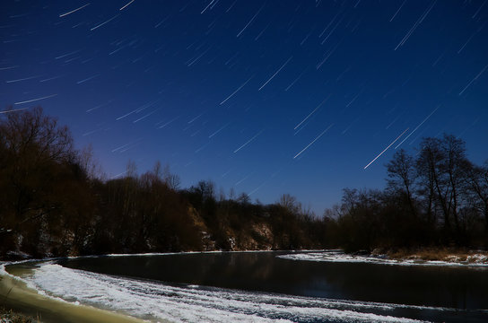 Fototapeta startrails / jasna, księżycowa, zimowa, mroźna noc nad rzeką 