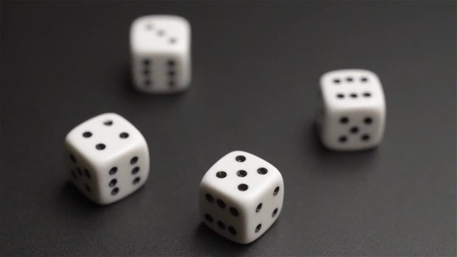 Four dice rolling on black background

