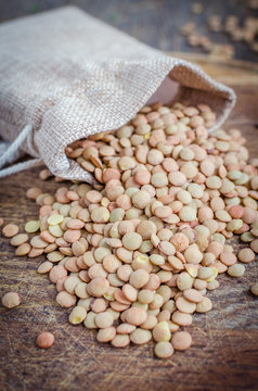 Brown dried lentils in a burlap bag