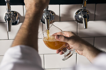 A bartender pours a beer at an upscale bar.