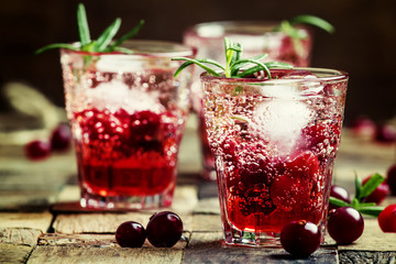 Two-layer cocktail with cranberry vodka, rosemary, soda and ice,