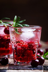 Two-layer cocktail with cranberry vodka, rosemary, soda and ice,