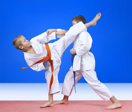 Two athletes in karategi beat kick arm and leg