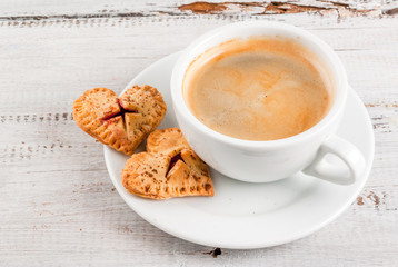 Idea for the celebration of Valentine's Day: big cherry pie and one-bite cherry pies in the form of hearts, cup of coffee, top view