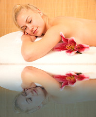 Obraz na płótnie Canvas Beautiful blonde woman enyoing massage treatment in sap salon