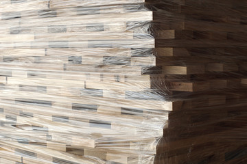 Wooden planks stacked in rows wrapped in plastic foil