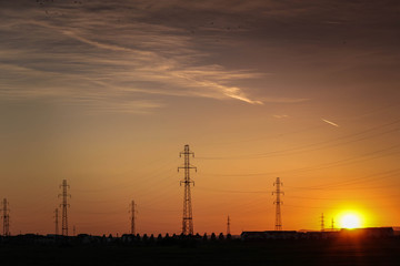 Electric grids in the sunset, picture showing electri grids in the sunset near a city during summer time