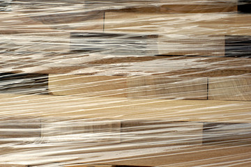 Fototapeta premium Wooden planks stacked in rows wrapped in plastic foil