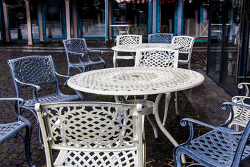 Empty metal tables and chairs in a street cafe in the fall.