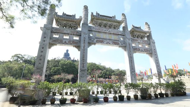 Time lapse of scenic gateway in a sunny day of Po Lin Monastery and the Big Buddha on background, icon and symbol of Lantau Island, popular tourist destination of Hong Kong, China.