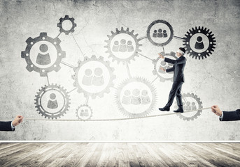Business concept of risk support and assistance with man balancing on rope