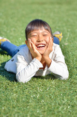 野原で頬杖をつく女の子