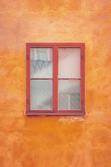 Fototapeta na wymiar Wooden window with orange plaster wall