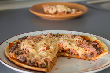 Frittata with tomato sauce, carrot, fried minced beef and cheese on white plate.