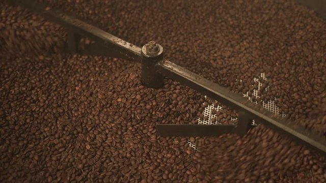 Male hands holding coffee beans over roaster