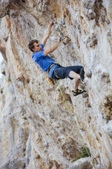 Male rock climber on challenging route on cliff