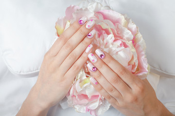 Closeup photo of a beautiful female hands with pink nail art design manicure and flower. - 134066374