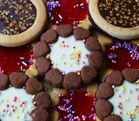 Assorted cookies with jelly center, chocolate, white cream and different sprinkles
