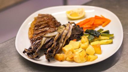 Preparing a dish of meat in a restaurant.