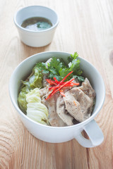 steamed chicken breast.White cup on a plate placed on a wooden t