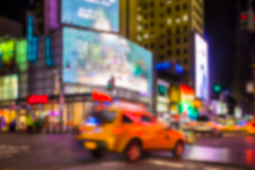 New York City night street scene defocused blur with lights and taxi. 