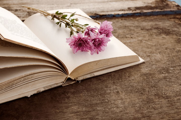 Obraz premium Vintage novel books with bouquet of flowers on old wood background - concept of nostalgic and remembrance in spring vintage background