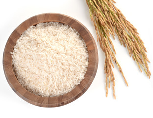 white rice on the wooden plate and rice plant , uncooked raw