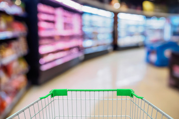 Supermarket aisle with shopping cart blurred background