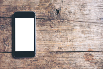 Mockup image of black mobile phone with blank white screen on vintage wood table background