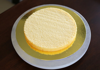 Cake in process on stand on wooden table, Homemade Cake.