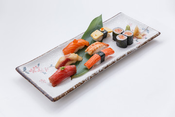 Sushi Set Include Maguro, Hamachi, Salmon, Kani, Shrimp and Tamago Maki with Salmon Maki Rolls Served with Prickled Ginger and Wasabi in Japanese Painted Stone Plate.