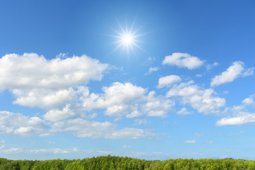 Blue sky with clouds and sun reflection