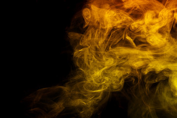 Abstract smoke Weipa. Personal vaporizers fragrant steam. The concept of alternative non-nicotine smoking. Yellow smoke on a black background. E-cigarette. Evaporator. Taking Close-up. Vaping.