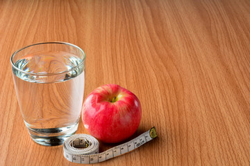 measuring tape, apple and water glass for healthy and body slim 