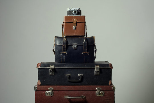 Stack of old shabby suitcases and camera