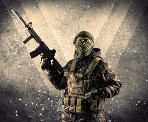 Portrait of a dangerous masked armed soldier with grungy backgro