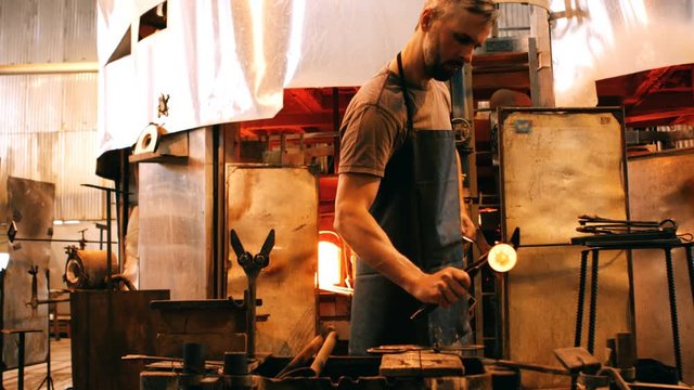 Glassblower shaping a molten glass