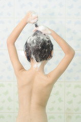 child n shower washing hair with shampoo